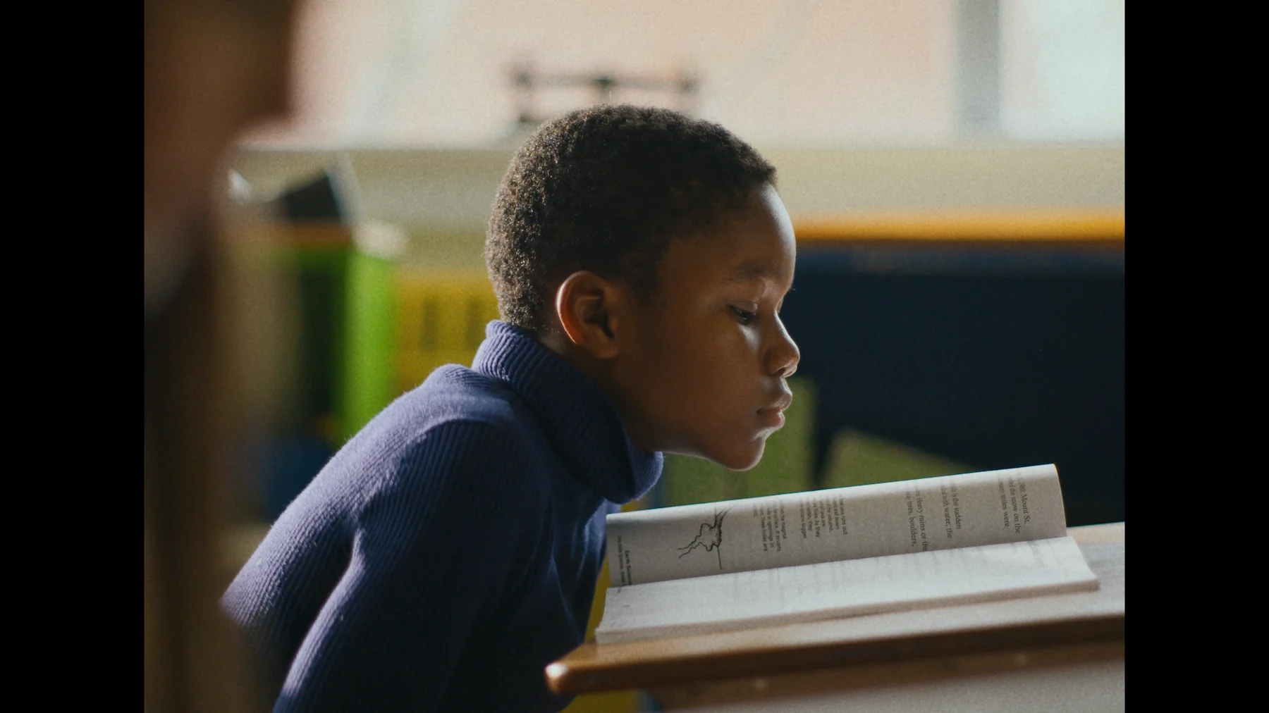 A young boy reading at a desk
