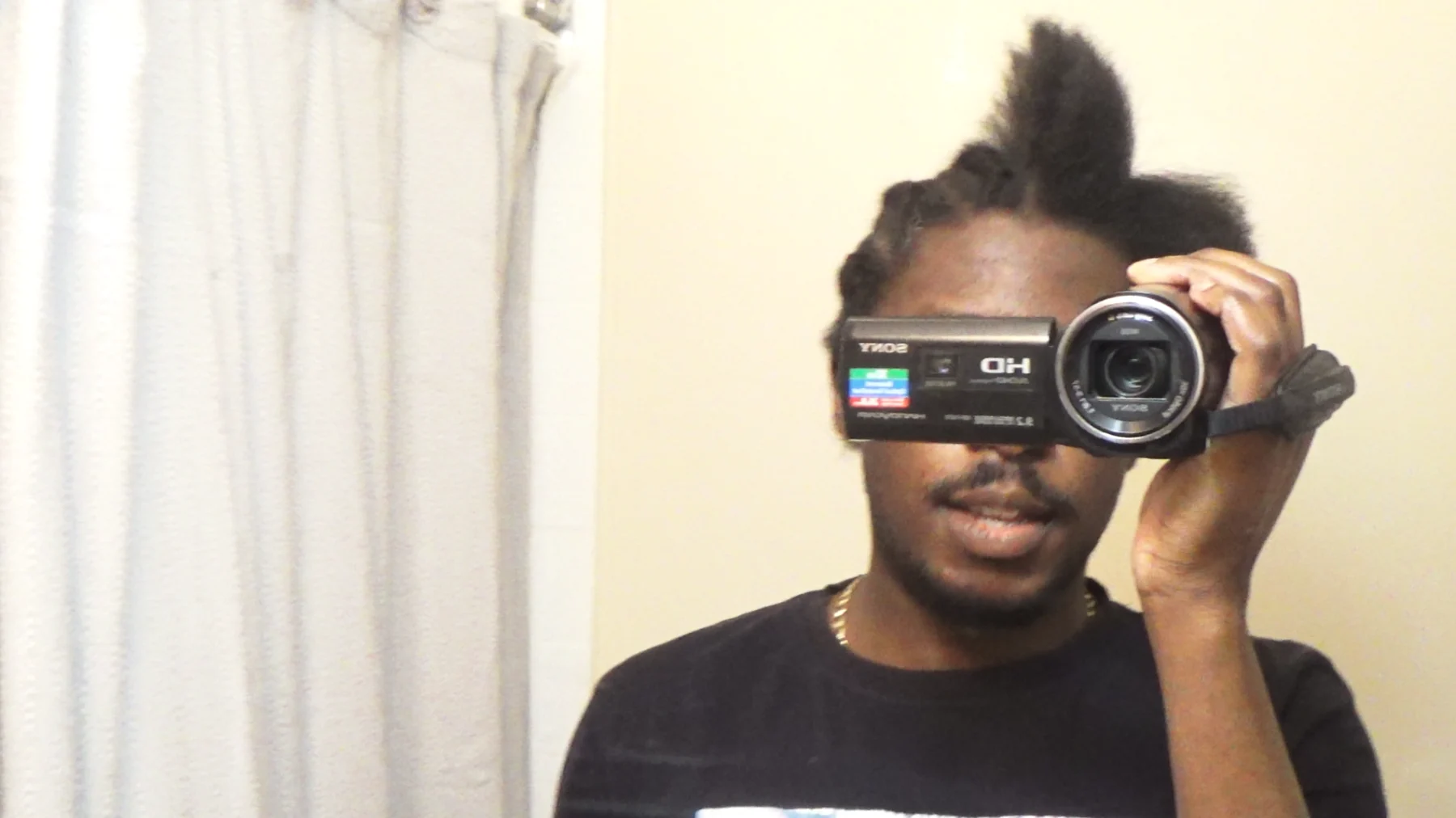 Gabriel filming himself with a handheld camera