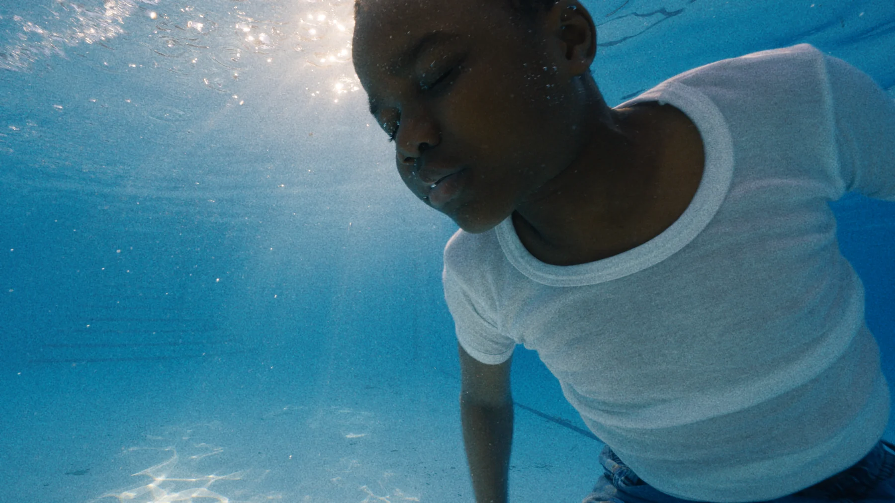 A young boy underwater in a swimming pool